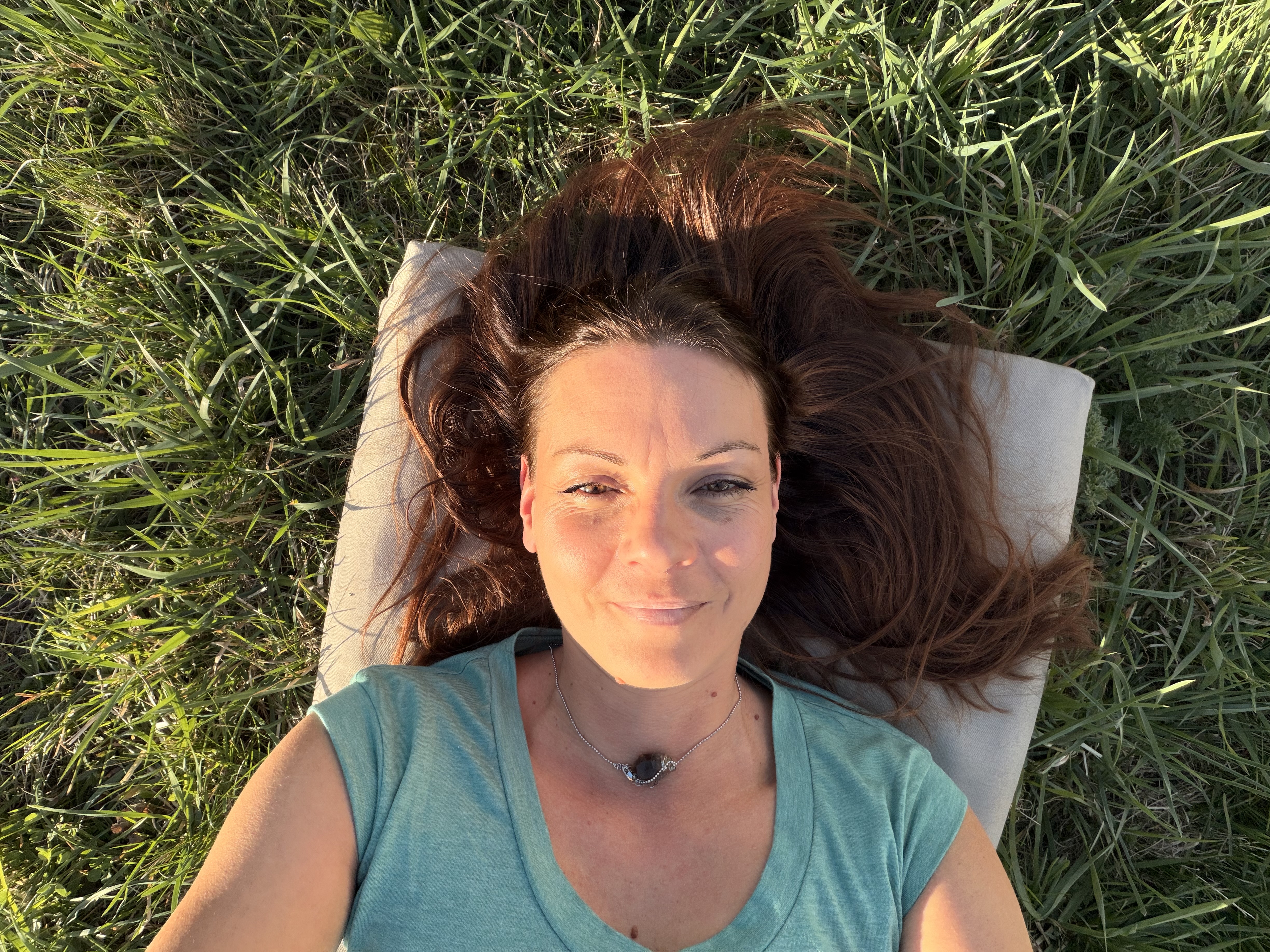 Melanie Gruber liegt entspannt im Gras, Vogelperspektive